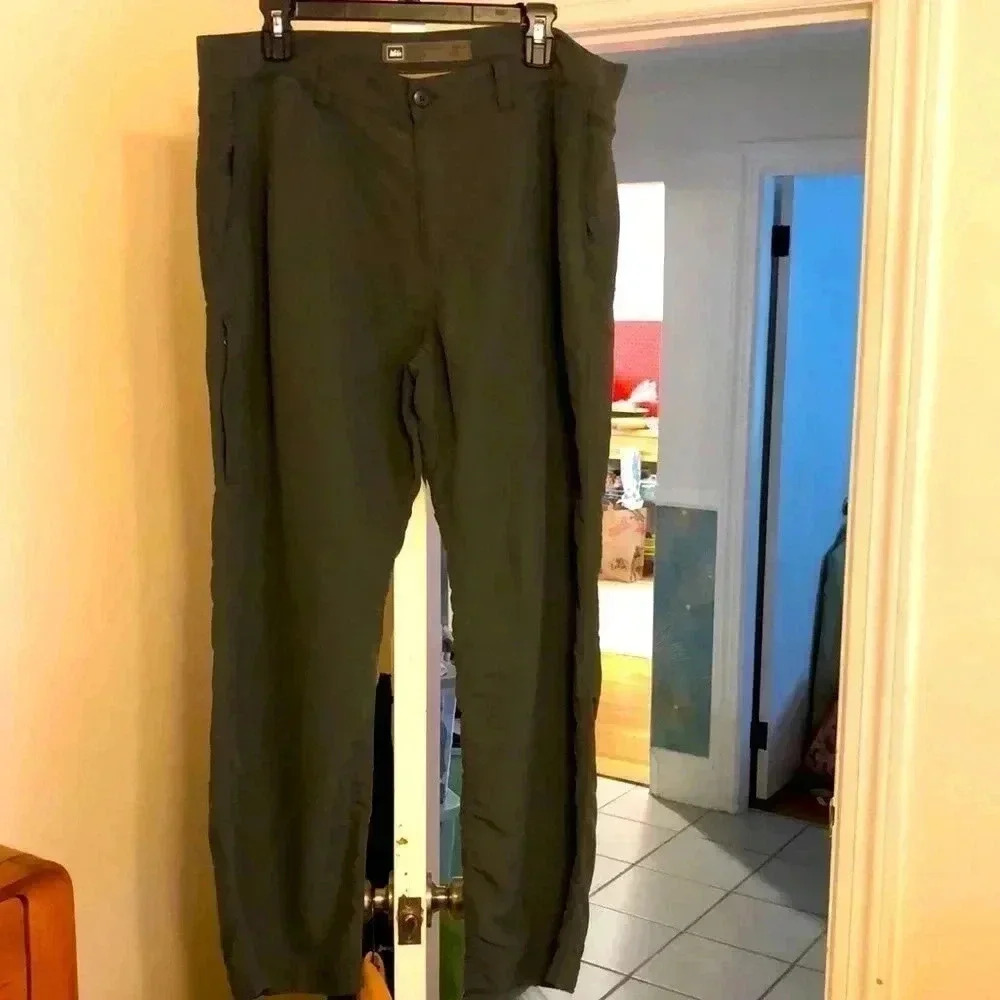 REI nylon green long pants. Open side pockets and zippered pocket on leg.